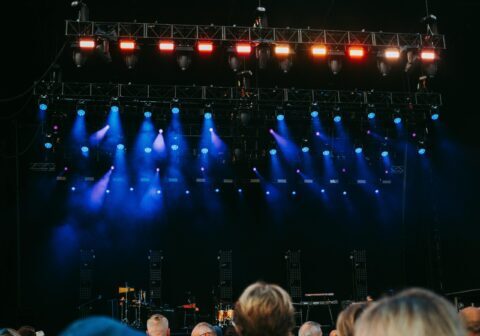 Night concert scene with audience, stage, and colorful lighting effects.
